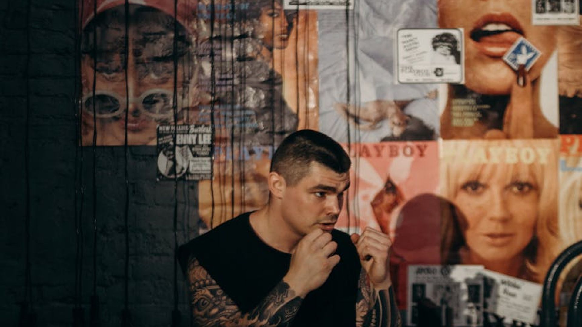 Strong athletic man focused on workout in a dark gym.